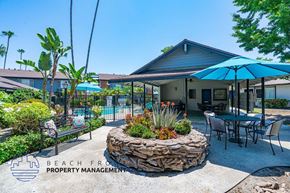 Anaheim apartment for rent - a patio with tables and umbrellas and a house