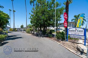 Anaheim apartment for rent - a street with a beach front property management sign and palm trees
