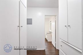 Long Beach apartment for rent - A hallway with white doors and a logo for Beach Front Property Management.
