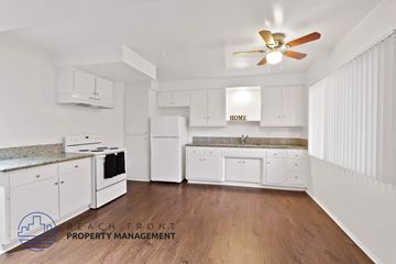 Long Beach apartment for rent - A kitchen with white cabinets and a wooden floor.