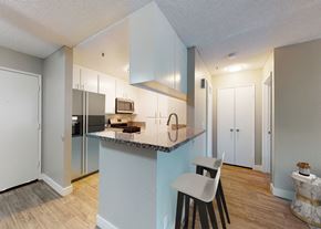 Paramount apartment for rent - A kitchen with a white chair and a counter with a sink.