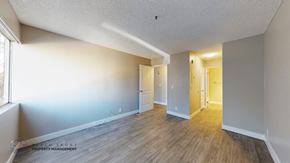 Paramount apartment for rent - A spacious room with wooden flooring and white walls.