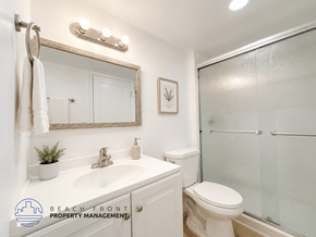 San Pedro apartment for rent - A bathroom with a white toilet, sink, and mirror.