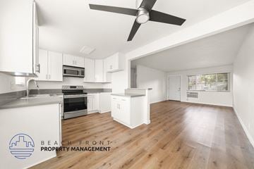 Whittier apartment for rent - A spacious kitchen with white cabinets and a wooden floor.