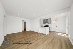 Santa Monica apartment for rent - a renovated living room and kitchen with white walls and wood flooring