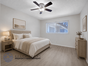 Inglewood apartment for rent - A well-lit bedroom with a large bed, a ceiling fan, and a nightstand with a lamp.