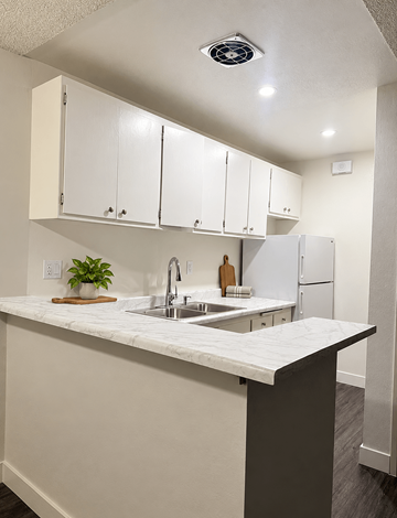 Torrance apartment for rent - A kitchen with white cabinets and a marble countertop.
