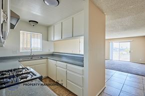 Long Beach apartment for rent - A kitchen with a stove, sink, and cabinets.