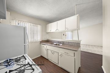 Gardena apartment for rent - A kitchen with a stove top oven and white cabinets.