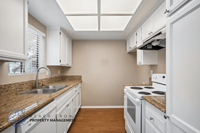 Lakewood apartment for rent - A kitchen with white cabinets and a granite countertop.