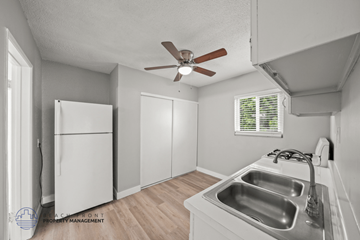 Inglewood apartment for rent - A kitchen with a white fridge, sink and a ceiling fan.
