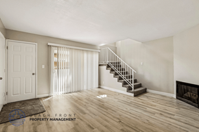 Huntington Beach apartment for rent - A living room with a staircase and a fireplace.
