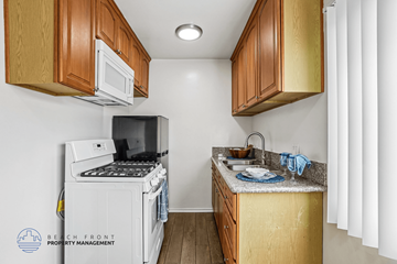 Downey apartment for rent - A kitchen with wooden cabinets and a white refrigerator.