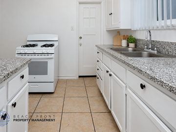 Long Beach apartment for rent - A kitchen with white appliances and cabinets.