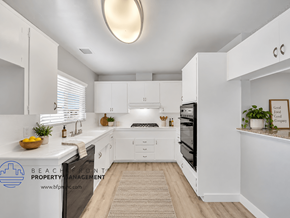 Downey apartment for rent - A clean, white kitchen with a skylight and a fridge on the left.