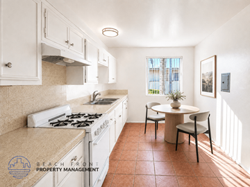 Lynwood apartment for rent - A kitchen with a stove top oven and a dining table with chairs.