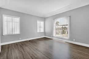 Long Beach apartment for rent - A room with wooden floors and two windows.
