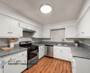 Stanton apartment for rent - A kitchen with white cabinets and a black stove top oven.