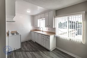 Long Beach apartment for rent - A kitchen with white cabinets and a window with blinds.