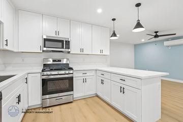 Long Beach apartment for rent - A kitchen with white cabinets and a stainless steel stove top oven.