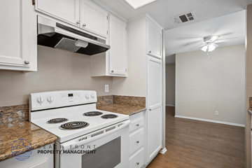 Lakewood apartment for rent - A kitchen with a white stove top oven and white cabinets.