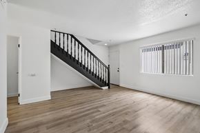 Westminster apartment for rent - A spacious room with a wooden floor and a staircase.
