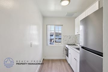 Hawthorne apartment for rent - A kitchen with a stainless steel refrigerator and wooden floors.