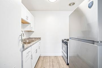 Anaheim apartment for rent - A kitchen with white cabinets and a stainless steel oven.