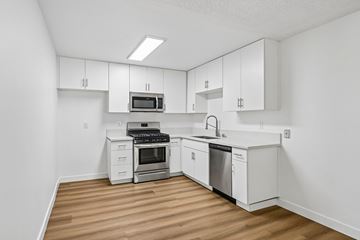 San Pedro apartment for rent - A kitchen with white cabinets and appliances.