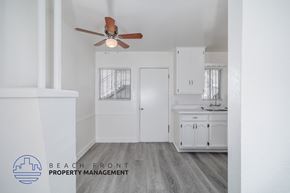 Comption apartment for rent - A white bathroom with a fan and a logo for Beach Front Property Management.