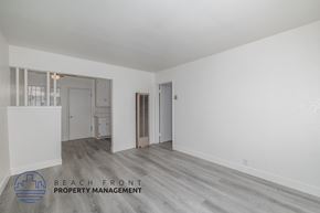 Comption apartment for rent - A spacious room with a logo for Beach Front Property Management in the corner.