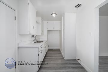 Comption apartment for rent - A kitchen with white cabinets and a countertop.