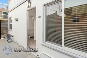 Huntington Beach apartment for rent - A white building with a sign that says Beach Front Property Management.