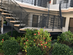 Inglewood apartment for rent - A staircase with a black railing and a building in the background.