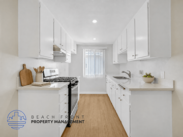 Downey apartment for rent - A kitchen with white cabinets and a wooden floor.