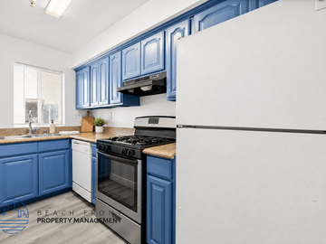 Van Nuys apartment for rent - A kitchen with blue cabinets and a white refrigerator.