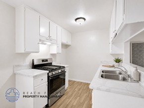 Harbor City apartment for rent - A kitchen with white cabinets and a stove top oven.