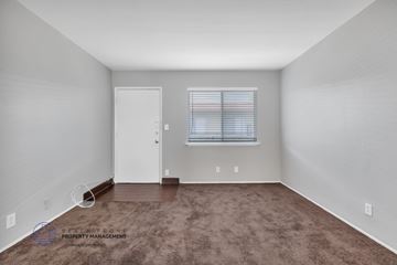 Carson apartment for rent - the living room of an apartment with a brown carpet and a window