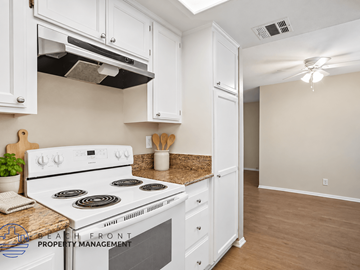 Lakewood apartment for rent - A kitchen with a stove top oven and white cabinets.