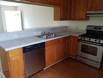 Harbor City apartment for rent - A kitchen with wooden cabinets and a stainless steel dishwasher.