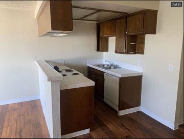 San Pedro apartment for rent - A kitchen with a white stove top oven and a white dishwasher.