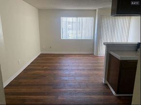 San Pedro apartment for rent - A room with wooden floors and a window with blinds.