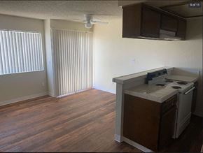 San Pedro apartment for rent - A kitchen with a white stove top oven and a white microwave above the counter.