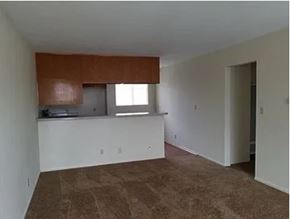 Harbor City apartment for rent - A room with a brown carpet and white walls.
