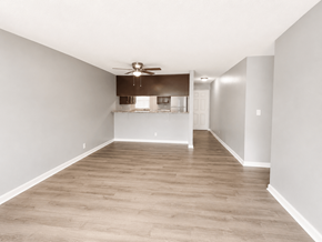 Long Beach apartment for rent - A spacious room with a ceiling fan and a kitchenette in the background.