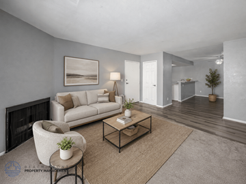 West Covina apartment for rent - A living room with a white couch, a chair, a coffee table, and a painting on the wall.