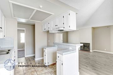 Hawthorne apartment for rent - A kitchen with white cabinets and a refrigerator.