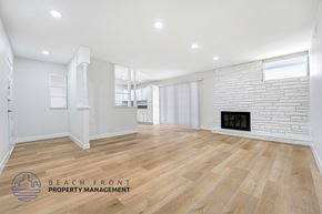 Granada Hills apartment for rent - A spacious room with wooden flooring and a fireplace.
