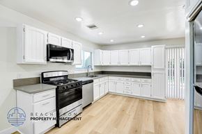 Granada Hills apartment for rent - A kitchen with white cabinets and a wooden floor.