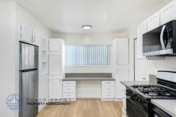 Granada Hills apartment for rent - A kitchen with white cabinets and a stove top oven.